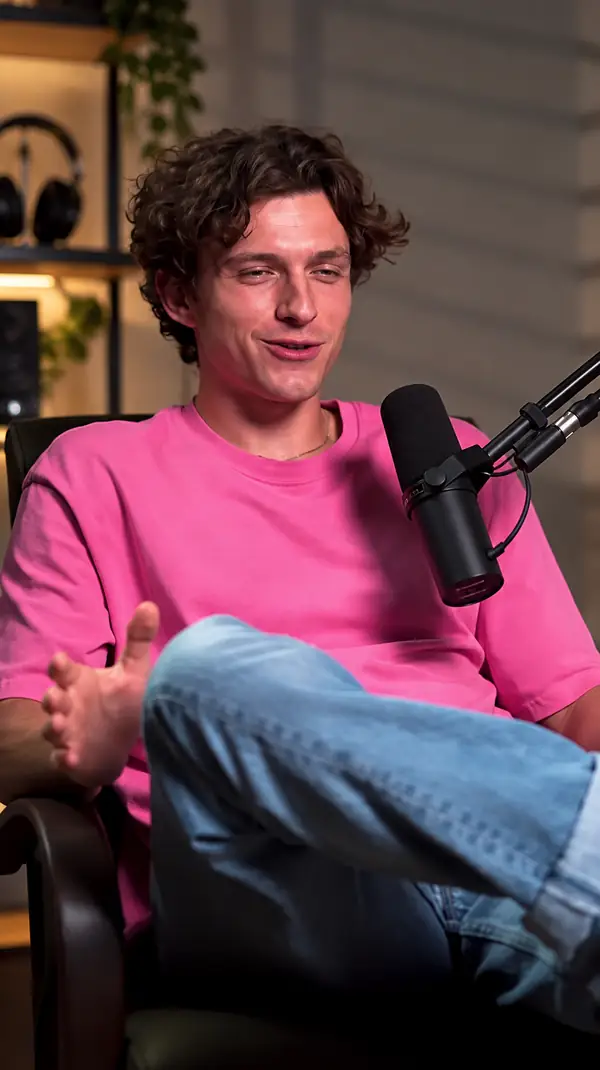 Man speaking into a podcast microphone, portrait video still